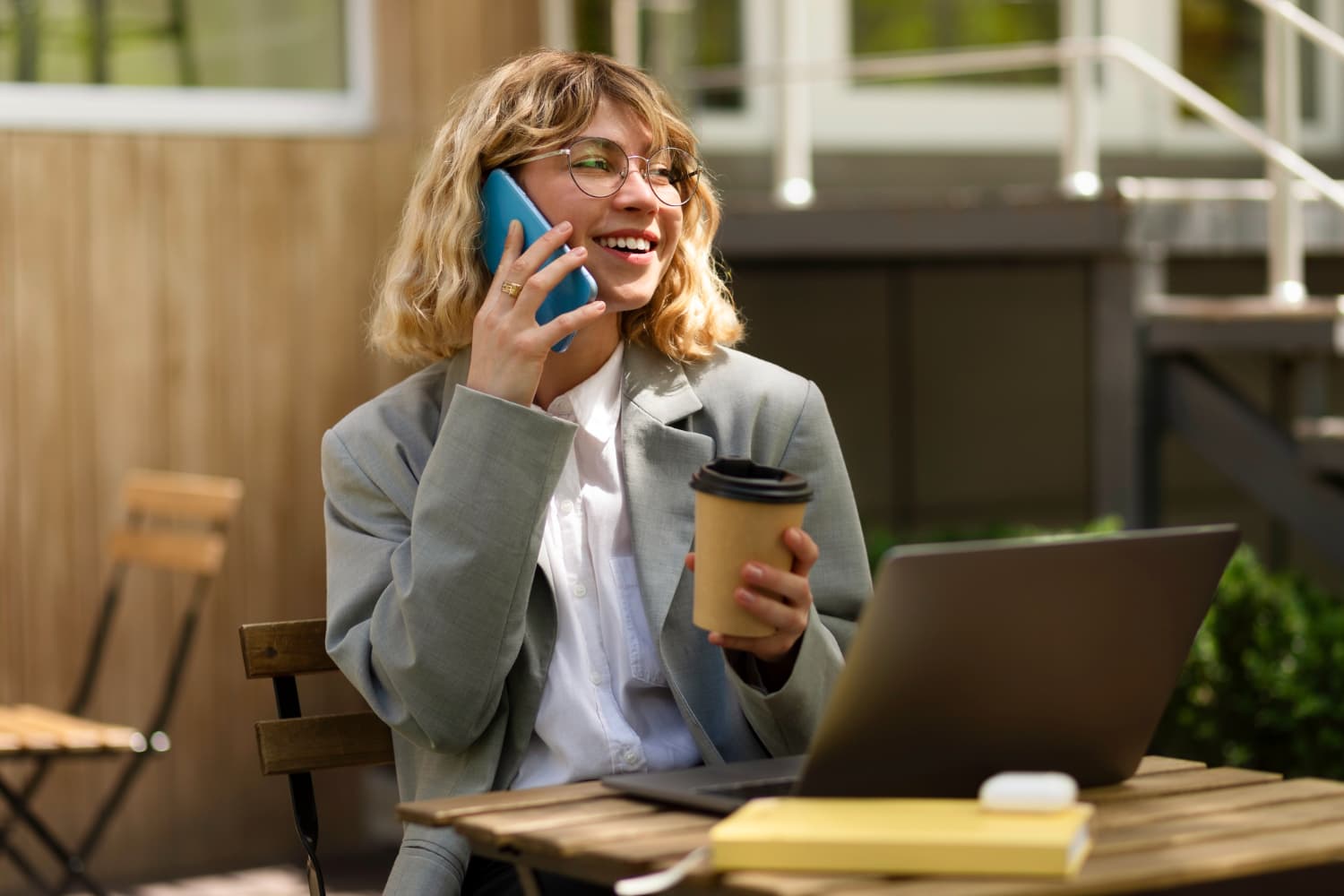 lady holding a coffee cup and a phone to her ear